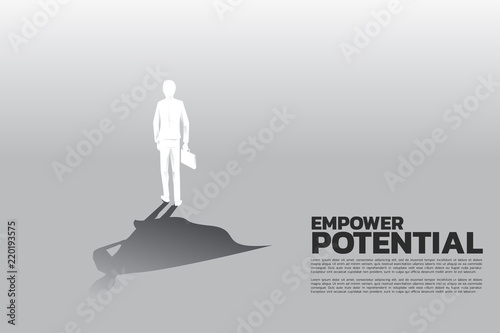 Silhouette of businessman with briefcase and his shadow of superhero.concept of empower potential and human resource management