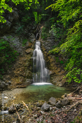 Wasserfall with mossy rocks and green trees