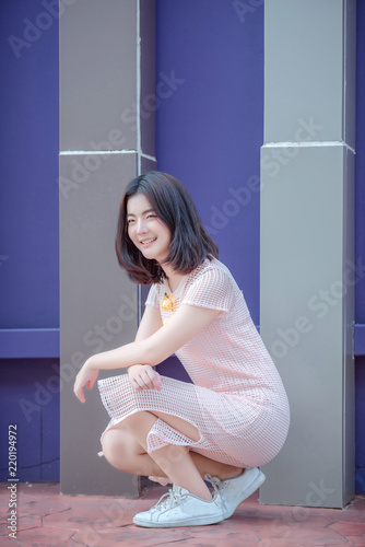 young beautiful stylish woman walking in pink coat, holding purse in hands, smiling, happy, street style, spring summer trend, black skirt, white shirt, flirty