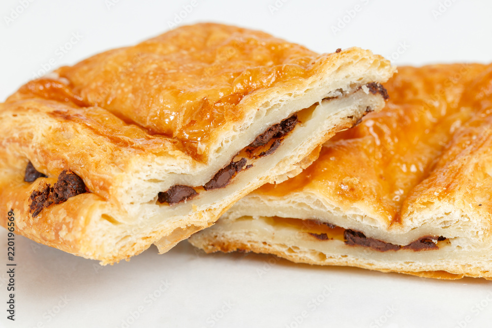Tasty puff pastry dessert cut in half . Delicious pastries with chocolate on light background. Tasty puff pastry dessert cut in half . Delicious pastries with chocolate on light background.