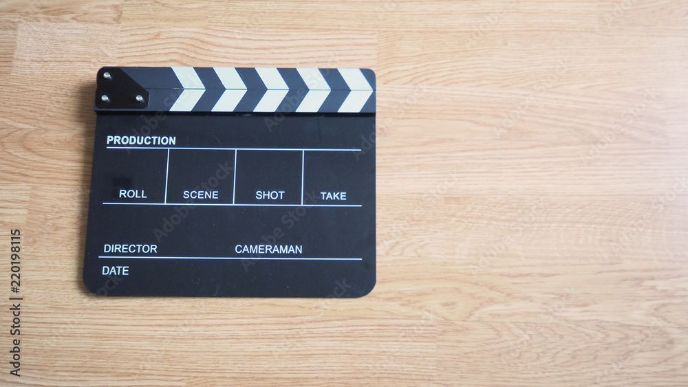 Obraz premium Clapper board or movie slate use in video production or movie and cinema industry. It's black color on wood background.