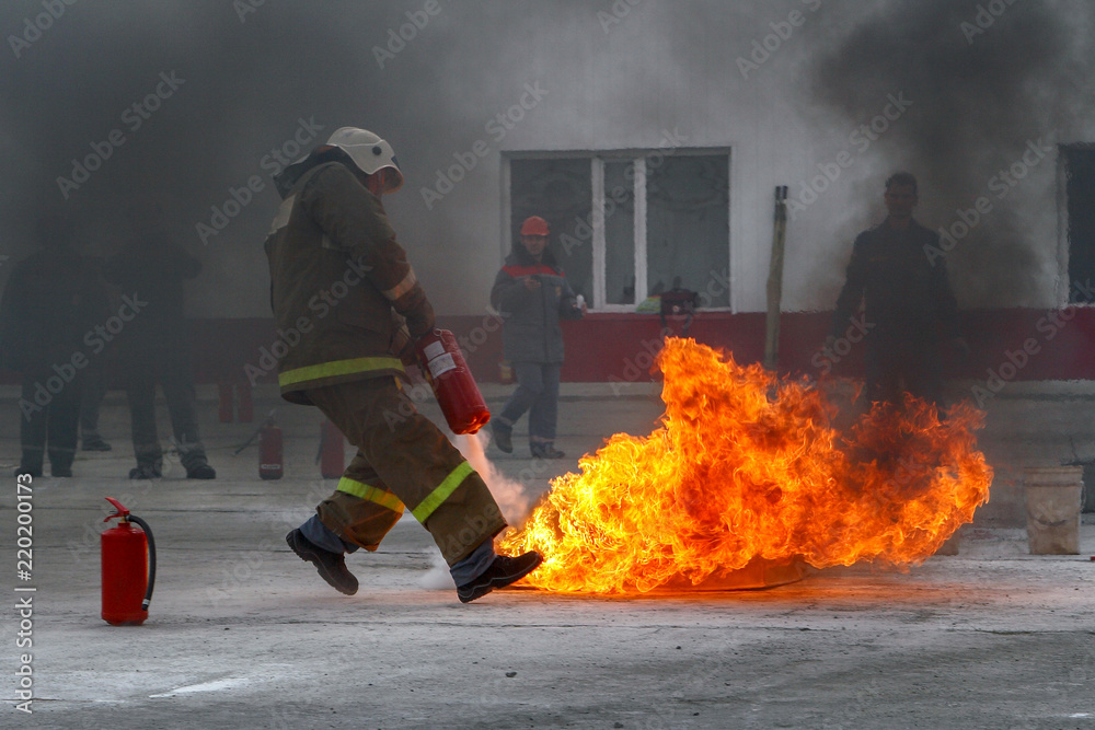 Competitions firefighters. The fireman works with a fire extinguisher to  extinguish the fire. Stock Photo | Adobe Stock