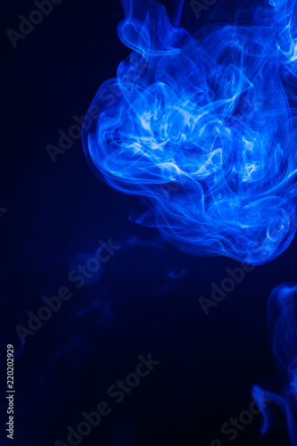 Blue smoke on black background. © peterkai