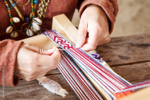 woman weaving bracelet out of thread