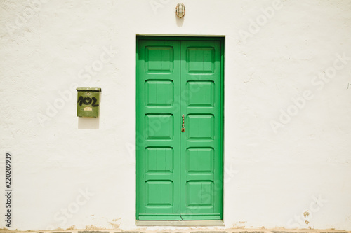 A front view of a old Georgian Green Door on white wall background