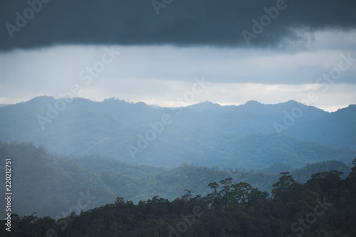 Landscape image of greenery rainforest hills on rainy day with cloudy sky background