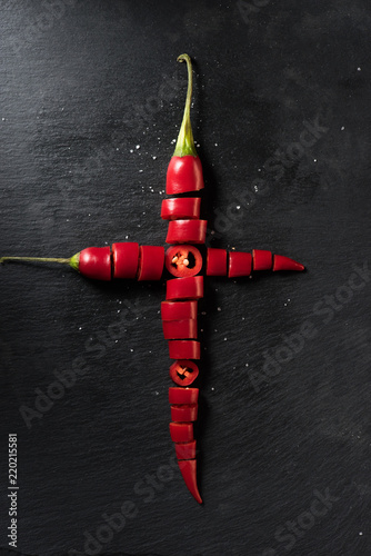 elevated view of two cut red ripe chili peppers on black surface
