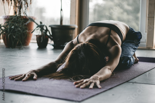Woman in Yoga Pose practice stretching pilates movement relaxing in home class interior indoors with plant