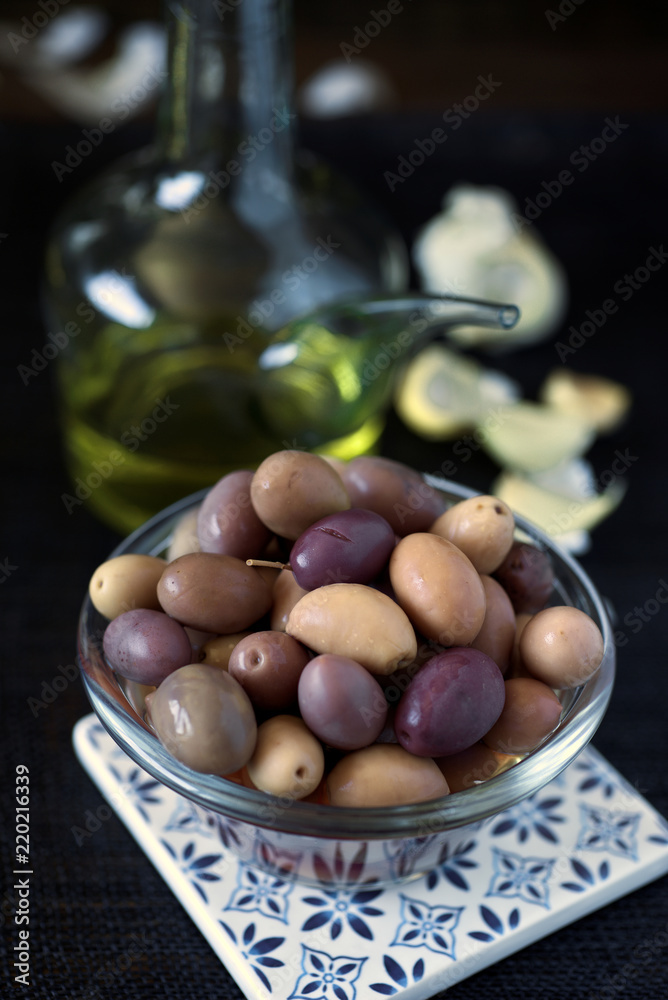 olive olive oil and condiments on dark burlap background olive olive oil and condiments on dark burlap background