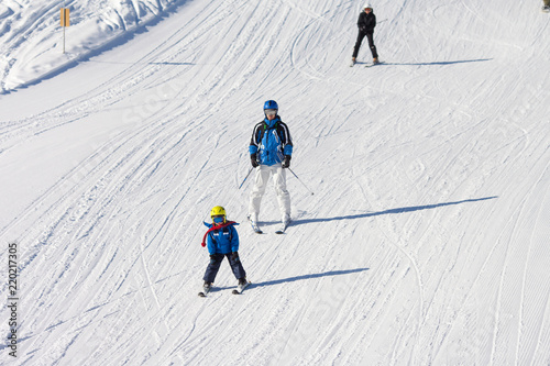 Father and son, preschool child, skiing in austrian ski resort in the mountains