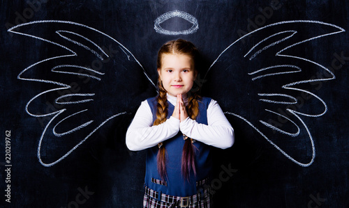  schoolgirl against chalkboard, with drawn angel wings
