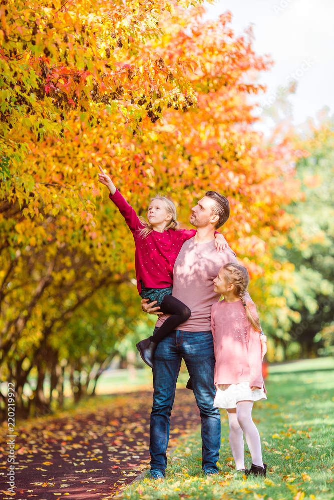 Fototapeta premium Family of dad and kids on beautiful autumn day in the park