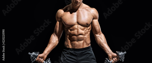 Sporty man working out with dumbbells. Photo of muscular naked torso on black background. Strength and motivation