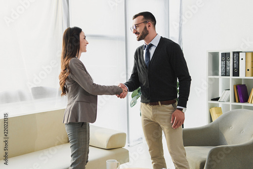 Bilde på lerret side view of happy patient and psychologist shaking hands in doctors office