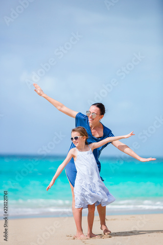 Beautiful mother and her adorable little daughter at beach