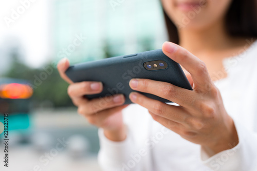 Woman playing game on cellphone at outdoor