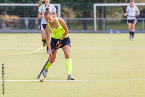 Young hockey player woman with ball in attack playing field hockey game © skumer