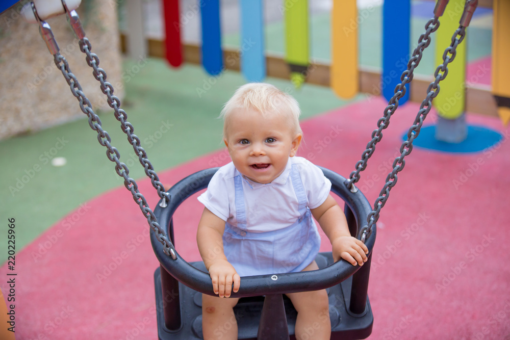 Adorable baby boy, playing with different rides on the playgdorund Adorable baby boy, playing with different rides on the playgdorund