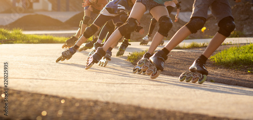 Obraz na plátně Group of teenagers skating on track in summer evening