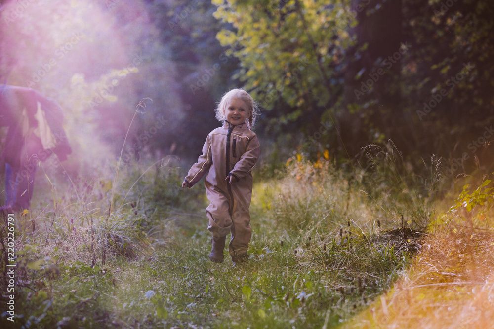 2 year old girl walking in the woods, lens flare and added grain