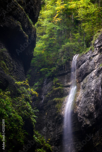 Detail of waterfall in forest. Foggy season in Partnach Gorge near Garmisch-Partenkirchen, Bavaria, Germany.