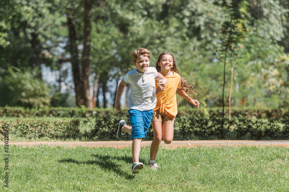 beautiful happy children running on grass in park