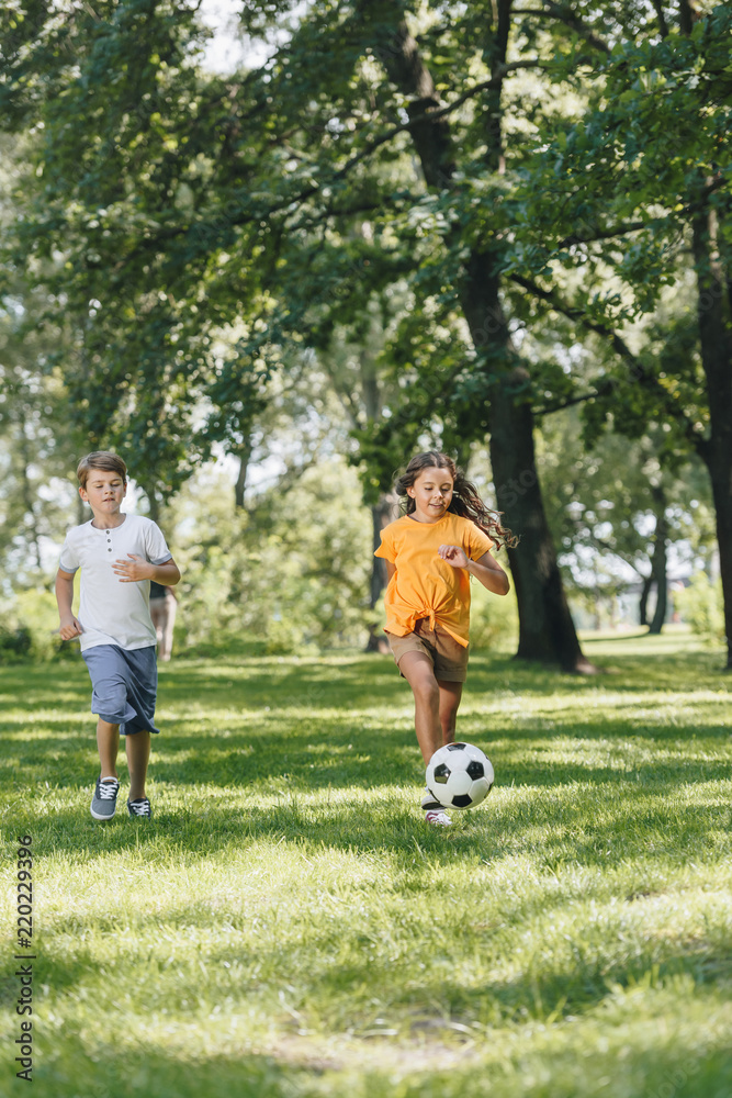 cute happy kids playing with soccer ball in park cute happy kids playing with soccer ball in park