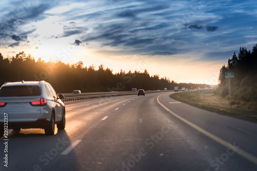 Car and light on the evening road. Sunset