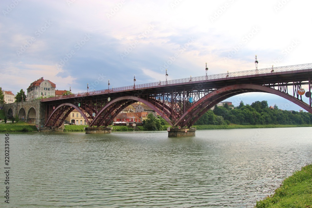 Maribor, Slovenia - July 6, 2018: The Old Bridge, or State Bridge, across the Drava river, in Maribor, Slovenia. 270 meters long, opened in 1913, with three steel arches. South-east Europe.