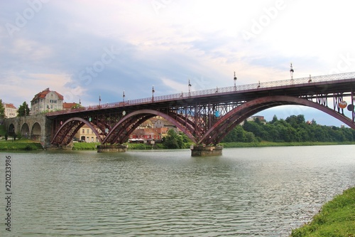 Maribor, Slovenia - July 6, 2018: The Old Bridge, or State Bridge, across the Drava river, in Maribor, Slovenia. 270 meters long, opened in 1913, with three steel arches. South-east Europe. © utamaria