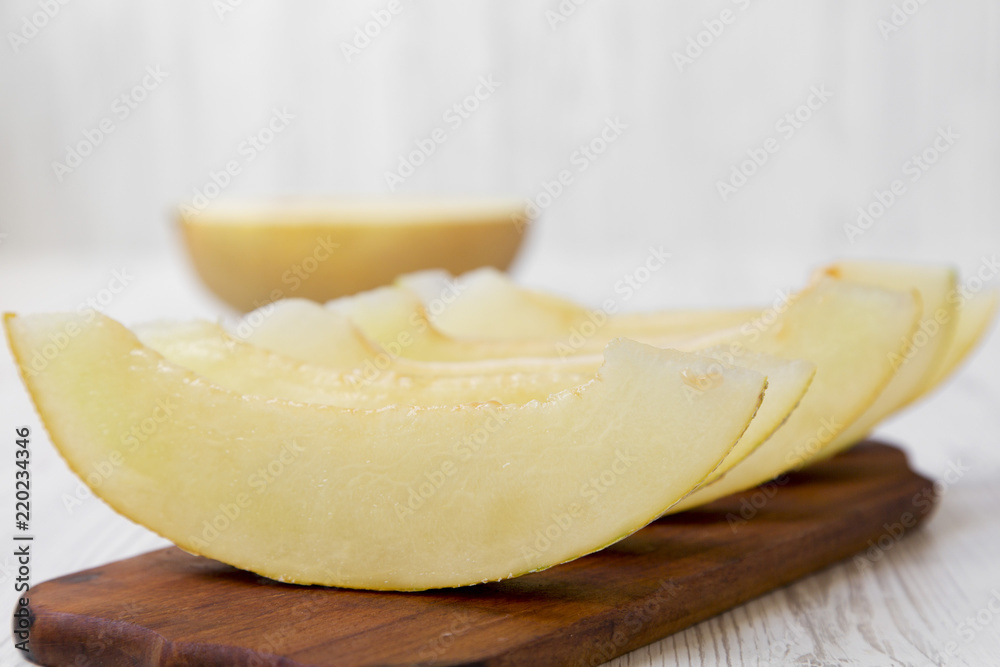 Sliced melon on rustic wooden board, side view. Close-up.