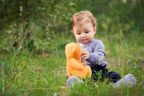 Little boy playing with brown Teddy bear
