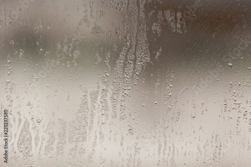 Wetted glass on the window as a background photo