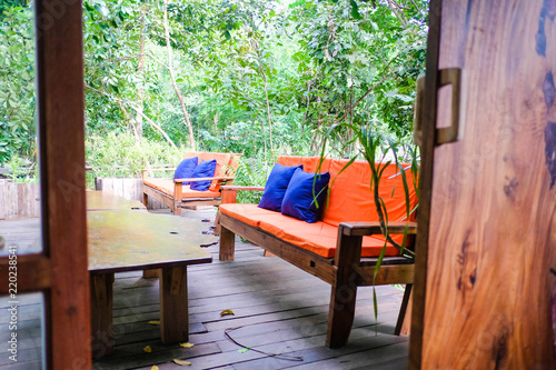 Orange sofa Color and wooden table in garden.