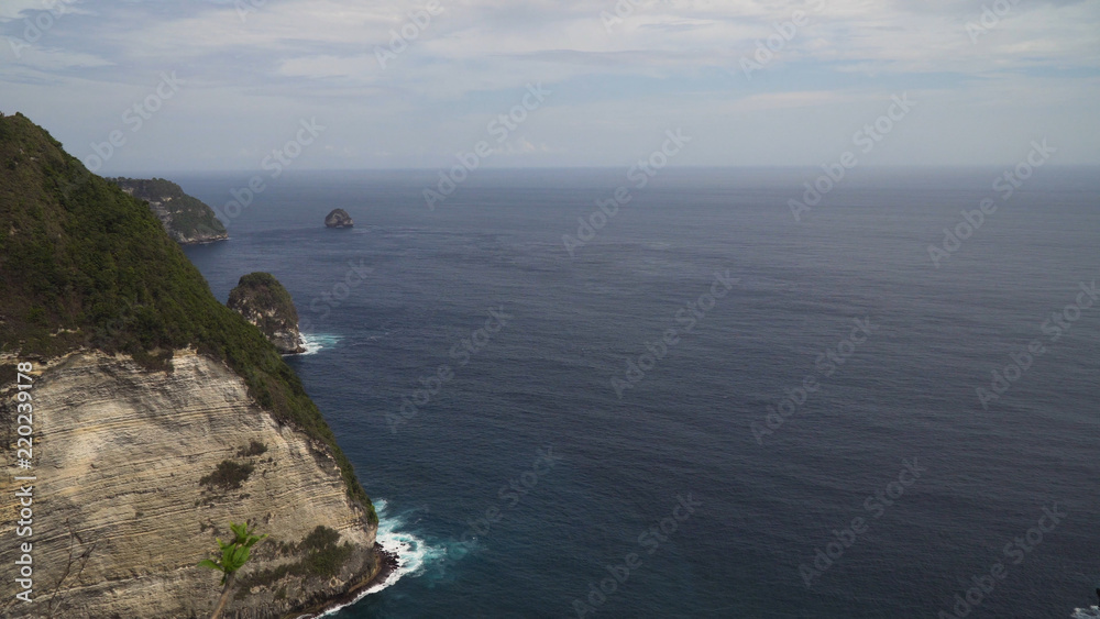 Seascape, rocky coast, ocean, blue sea, waves, Nusa Penida, Indonesia. Ocean with waves and rocky cliff Travel concept