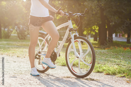 Young sporty woman with a bike, soft focus background