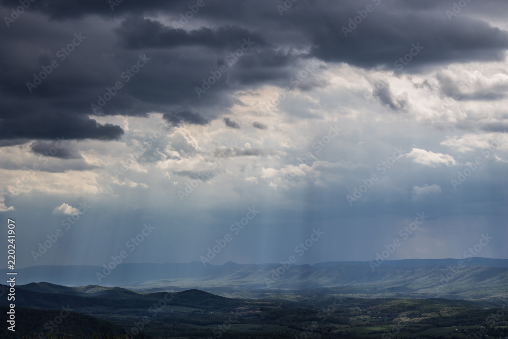 Shenandoah Valley National Park on a hazy summer day as the light breaks through the clouds casting shafts of light