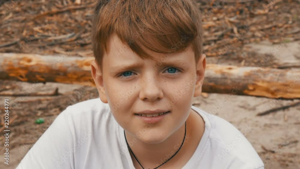 Emotional portrait of red-haired teenager boy with blue eyes and freckles that looks into the camera Emotional portrait of red-haired teenager boy with blue eyes and freckles that looks into the camera