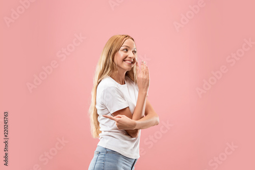Secret, gossip concept. Young woman whispering a secret behind her hand. Business woman isolated on trendy studio background. Young emotional woman. Human emotions, facial expression concept.