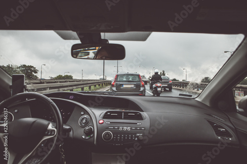 Driving a passenger car in traffic jam, view from inside on crowded road