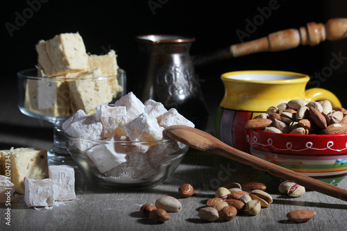 A mug of coffee and different oriental sweets: turkish delight, halva, almond and pistachio