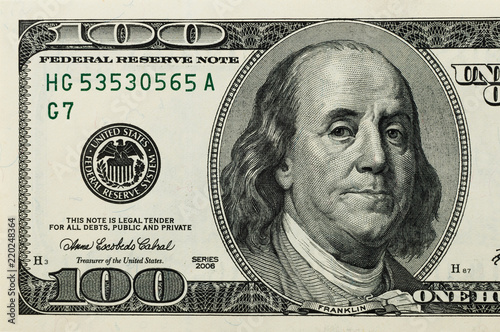 Part of the bill is one hundred US dollars. The left part. Close-up.