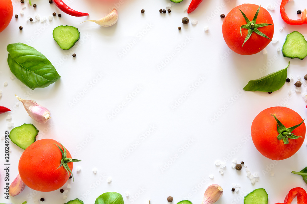 Colorful salad ingredients pattern made of tomatoes, pepper, chili, garlic, cucumber slices and  basil on white background. Cooking concept. Top view. Flat lay. Copy space
