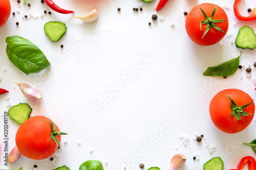 Colorful salad ingredients pattern made of tomatoes, pepper, chili, garlic, cucumber slices and basil on white background. Cooking concept. Top view. Flat lay. Copy space