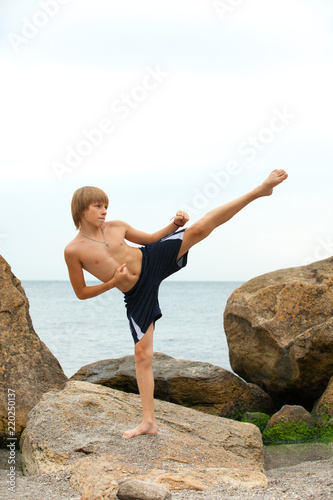Boy practicing karate on the seashore