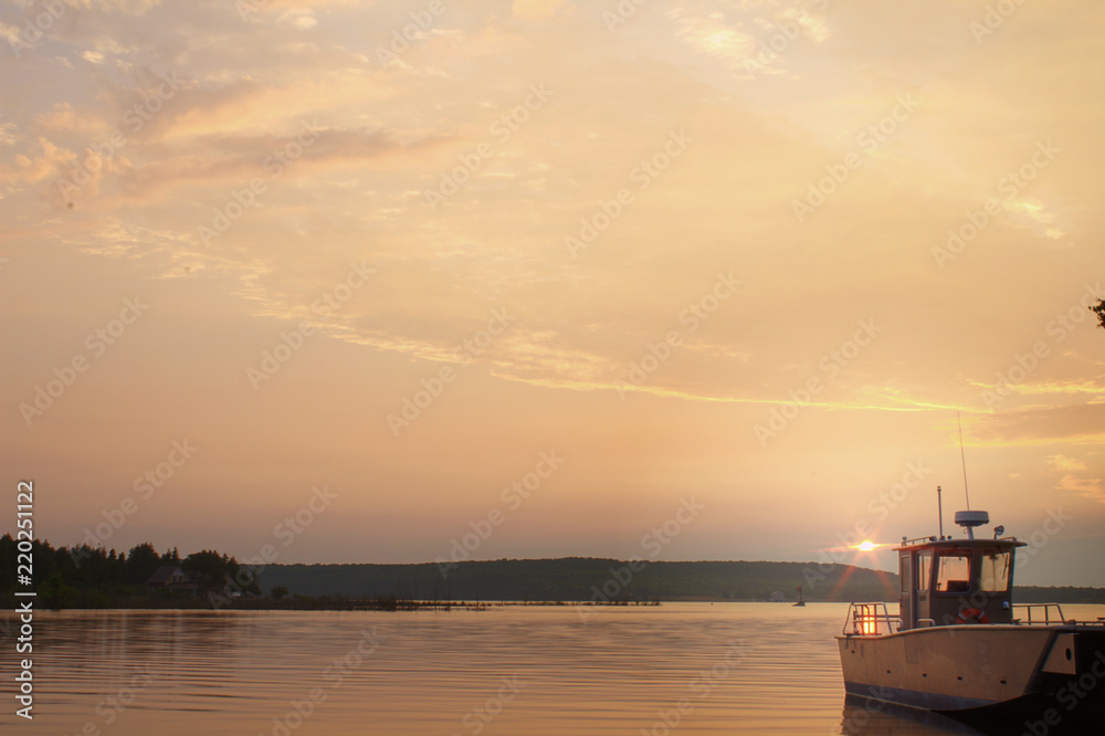 Single Silver Metal Shiny Nautical Sailing Motor Boat Isolated Alone at Dock with Pink Purple Orange Sunrise Reflecting in Calm Ocean Lake Water