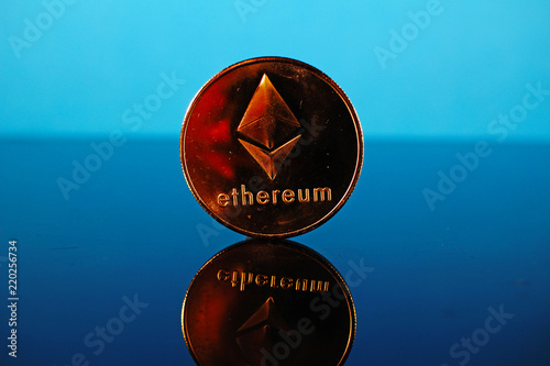 Etherum money crypto currency coin on reflective colorful background photo