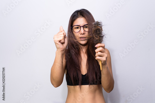Woman with hair loss holding comb. Young girl losing  hair problem, falling hair on brush healthy medical treatment concept.