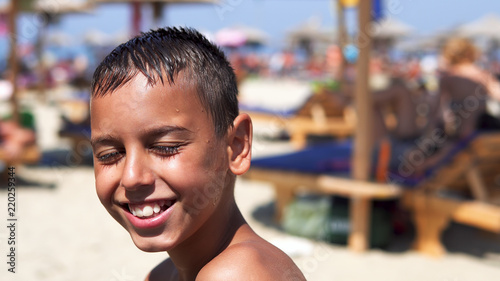 Happy hispanic boy on beach smiling to camera, cinematic dof