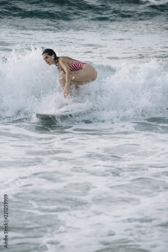 Young woman surfing the wave on his surfboard © karrastock